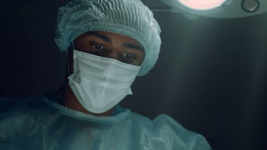 Yoğun bakım ünitesinin portresinde cerrahi operasyon yapan odaklanmış bir cerrah..