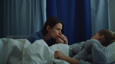 Modern hastane koğuşunda cerrahi tedaviden sonra hasta kızına bakan anne.. 