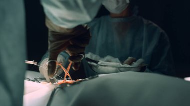 Hemşire asistanı klinik odasında ameliyat pratisyeni. Tıbbi ekip dikiş yarası.