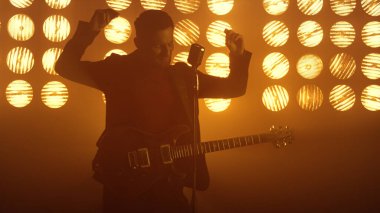 Sahnede sahne arkasında şarkı söyleyen seksi erkek gitarist. Şarkı söyleyen adam.