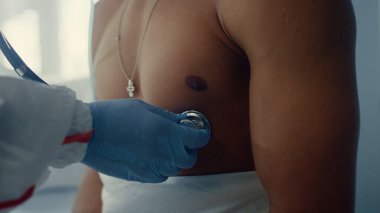 Doktor eller kalp atışı koğuşunu dinliyor. Salgın sırasında sağlık kontrolü.