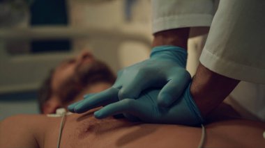 Hastane koğuşundaki baygın hastaya kalp masajı yapan yakın doktor..