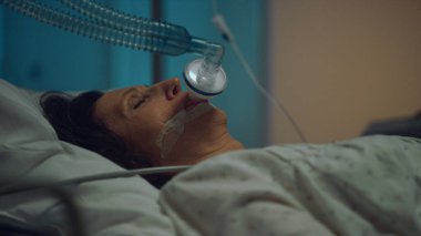 Nabız oksimetresi hastanede yakın plan. Oksijen maskeli yaşlı bir kadın..