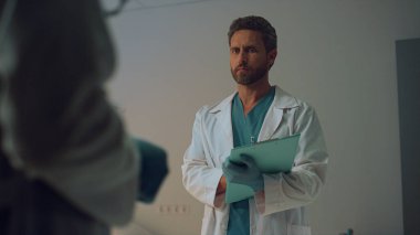 Doktor elinde bir not panosu tutuyor. Hastanede planlanmış randevu..