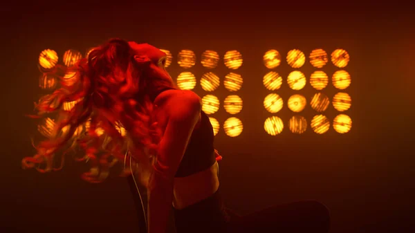 Tutkulu bir kadın saçını sallıyor ve gece kulübünde erotik dans yapıyor.. — Stok fotoğraf
