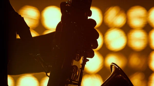 Musiker händer spelar saxofon jazz klubb närbild. Silhouette spelare hålla sax. — Stockfoto