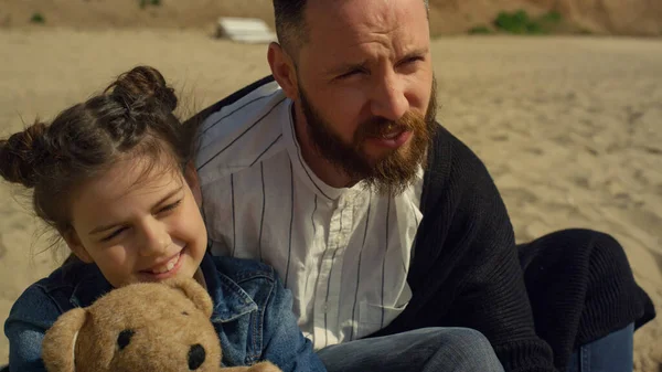 Babasının oğlu kumlu sahil denizinde birlikte vakit geçiriyor. Aile tatilde dinleniyor..