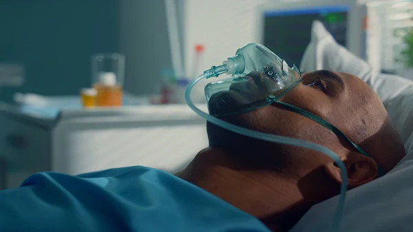 Arzt nimmt Tuben covid19 für Klinik-Test. Patient liegt in Sauerstoffmaske in Nahaufnahme — Stockfoto