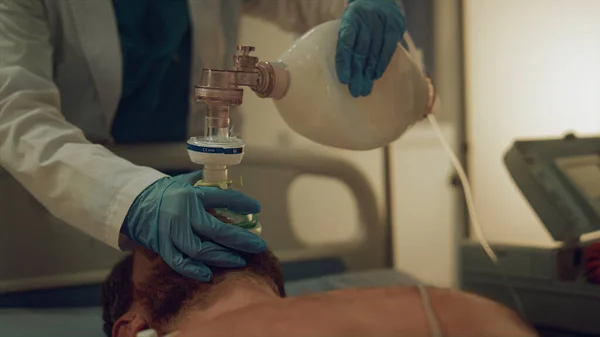 Ruka drží resuscitační vak v těsném záběru. Nemocniční personál zachránit život pacienta — Stock fotografie