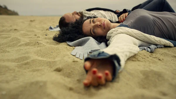 Ισπανόφωνος ζευγάρι ψύξη παραλία άμμο από τη θάλασσα. Χαλαρωμένοι εραστές ξαπλωμένοι στην παραλία. — Φωτογραφία Αρχείου