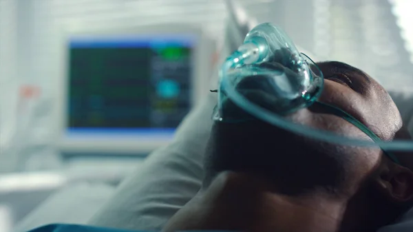 病棟で酸素マスクを呼吸患者の肖像画。窓のハートビートモニター. — ストック写真