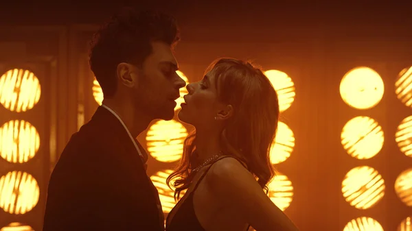 Kulüp ışıklarında şehvetli bir çift dans ediyor. Genç adam ateşli kızı okşuyor..