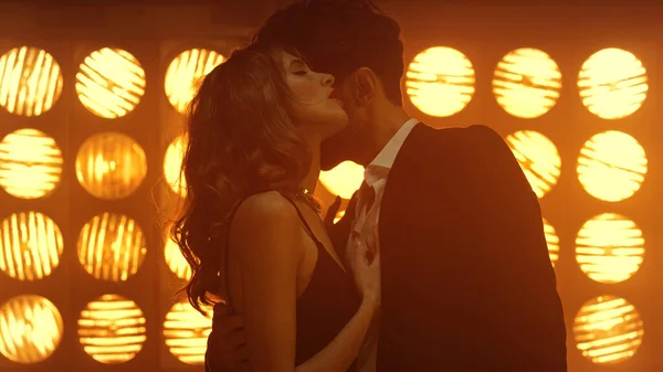 Kulüp ışıklarında erkekleri baştan çıkaran seksi bir kadın. Genç çift samimi danslar yapıyor..