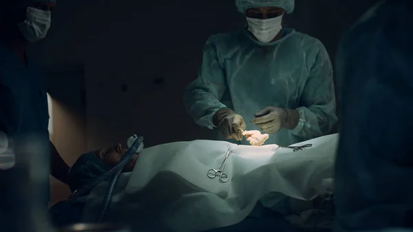Pielęgniarka zajmująca się sterylnymi instrumentami zbliżenie ciemni. Współpraca zespołu medycznego — Zdjęcie stockowe