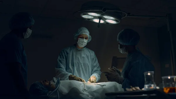 Ιατρική ομάδα εκτελεί χειρουργική επέμβαση στο δωμάτιο του νοσοκομείου. Όργανα διέλευσης χειρουργών. — Φωτογραφία Αρχείου