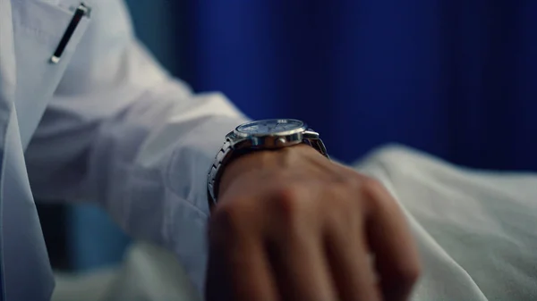 Dokter hand met horloge om pols close-up. Controle door therapeut op ziekenhuisafdeling. — Stockfoto