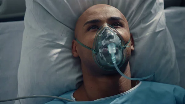 Porträt Patient atmet Sauerstoffmaske liegt im Bett Krankenhaus Notaufnahme. — Stockfoto