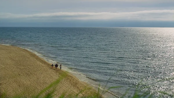 Huzurlu sahil kıyısı. Aile doğada yürüyor, kumlu sahil adasında.