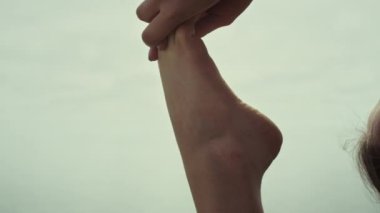 Sahilde çıplak ayakla gezen yakın plan kızı. Genç sporcu kadın yoga yapıyor..