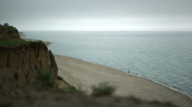 Yeşil tepeli görkemli kumlu sahil manzarası. Okyanus dalgaları altın plajı yıkıyor.