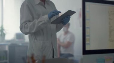 Modern ofis tabletindeki hasta bilgilerini daktilo eden tıp çalışanı..