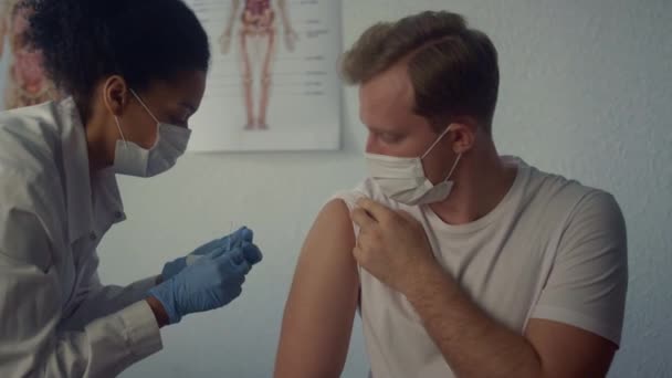 남성 어깨에 열렬 한 백신을 주사하는 여성 위생병. 주사기를 사용하는 의사. — 비디오