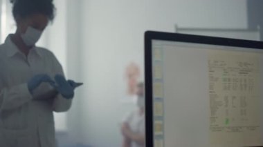 Woman doctor writing tablet computer standing office. Medic typing data on pad.