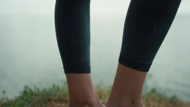 Sportliche Frauenbeine in Nahaufnahme am Strand. Starke Mädchenfüße auf trockenem Gras. — Stockvideo