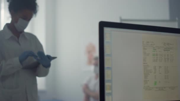 Mujer doctor escribiendo tableta computadora de pie oficina. Datos de mecanografía médica en el pad. — Vídeos de Stock