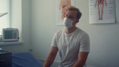 Clinic client waiting covid test results in office closeup. Man listening doctor
