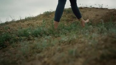 Athletic woman legs walking up hill close up. Unknown sporty girl climb hilltop.