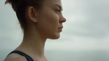 Beautiful girl doing breathing exercise outdoors. Sportswoman meditating yoga.