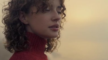 Closeup attractive girl looking at camera. Cheerful woman posing on beach