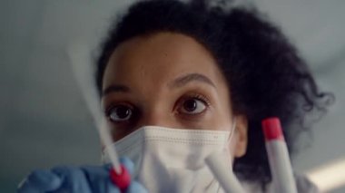 Corona testi için örnek alan kadın doktor. Yakın çekim. Hekim tüpü tutuyor..