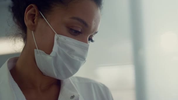 Porträt einer afrikanischen Krankenschwester im Gespräch mit einem Gesprächspartner in der Klinik. Arzt macht Kontrolluntersuchung. — Stockvideo
