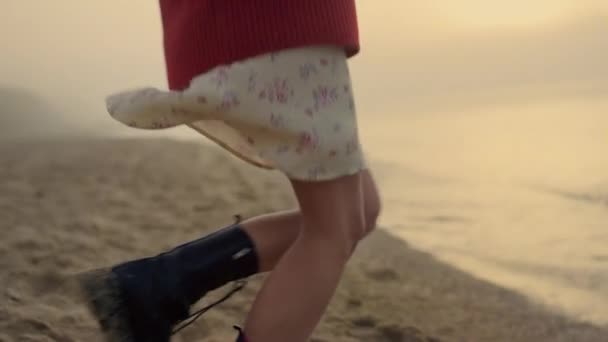 Aktive Frauenbeine tanzen am Strand. Lässiges Mädchen in trendigen Stiefeln dreht sich um — Stockvideo