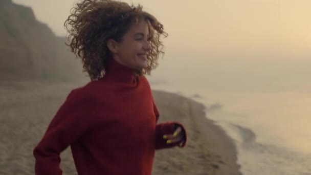 Nadšené děvče skákající na pláži. Usmívající se žena se otáčí na pobřeží — Stock video