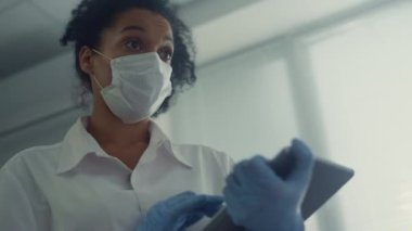 Doktor, dijital tablete yakın çekim notları yazan hastalara sağlık anketleri yürütür..