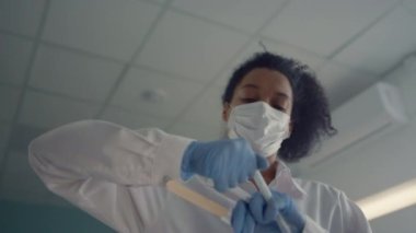 African nurse preparing cotton swab to collecting antigen tests close up.