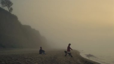 Güzel bir çift kumsalda vakit geçiriyor. Sevgili okyanusta dinleniyor.