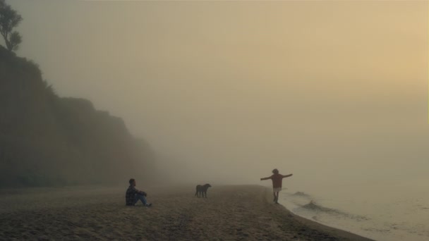 Young couple spending leisure time on beach. Girl and guy enjoying sunrise — Wideo stockowe