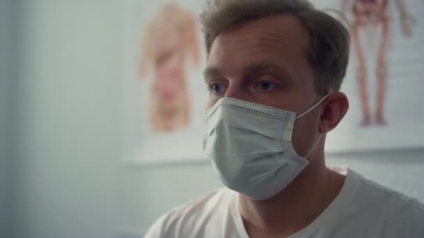 Porträtt patient väntar coronavirus test bär skyddsmask på sjukhus. — Stockvideo