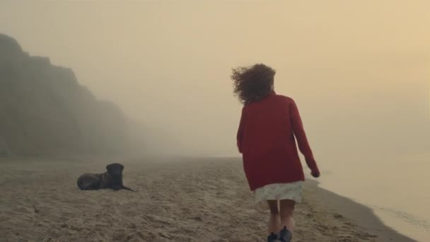 Lächelnde Frau posiert am Strand vor der Kamera. Glückliches Mädchen läuft am Meeresufer entlang — Stockvideo