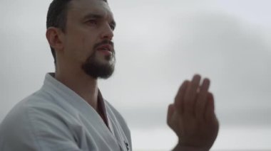 Sakallı adam dövüş sanatlarını öğreniyor. Sporcu doğa üzerinde egzersiz yapıyor..