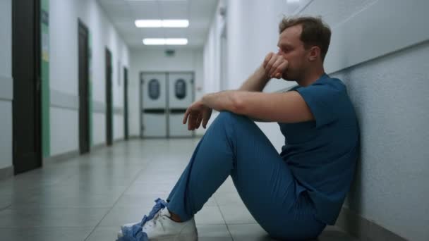 Depressiv läkare upplever hårda känslor sitter på kliniken hall närbild. — Stockvideo