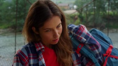 Maceracı kadın, doğa dağlarında kamera pozu veriyor. Gezgin sırt çantası koyuyor.