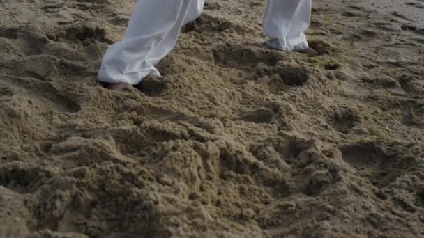 Голий чоловік стоїть на пляжі в карате позу крупним планом. Спортсмен тренує бойове мистецтво — стокове відео