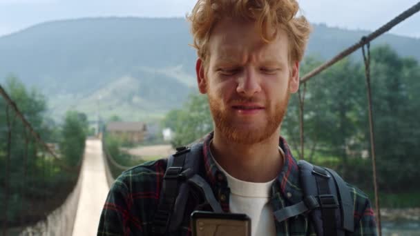 Sad traveler reading mobile phone screen. Hitchhiker looking map in mountains. — Wideo stockowe