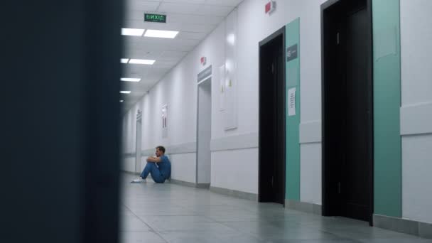 Pracownik medyczny siedzi na korytarzu karetki. Lekarz odpoczywa po operacji. — Wideo stockowe