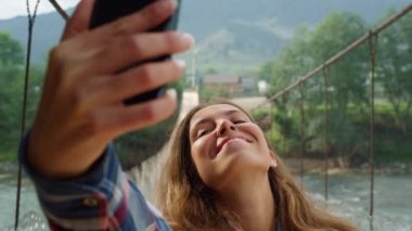 Güzel bir kadın fotoğraf çekiyor. Telefonu dağlarda doğa manzarasında kullanıyor..